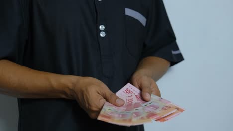 man counting  rupiah notes