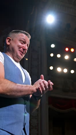 comedian on stage. middle-aged speaker standing on stage and talking to someone. smiling actor rehearses on scene. vertical video