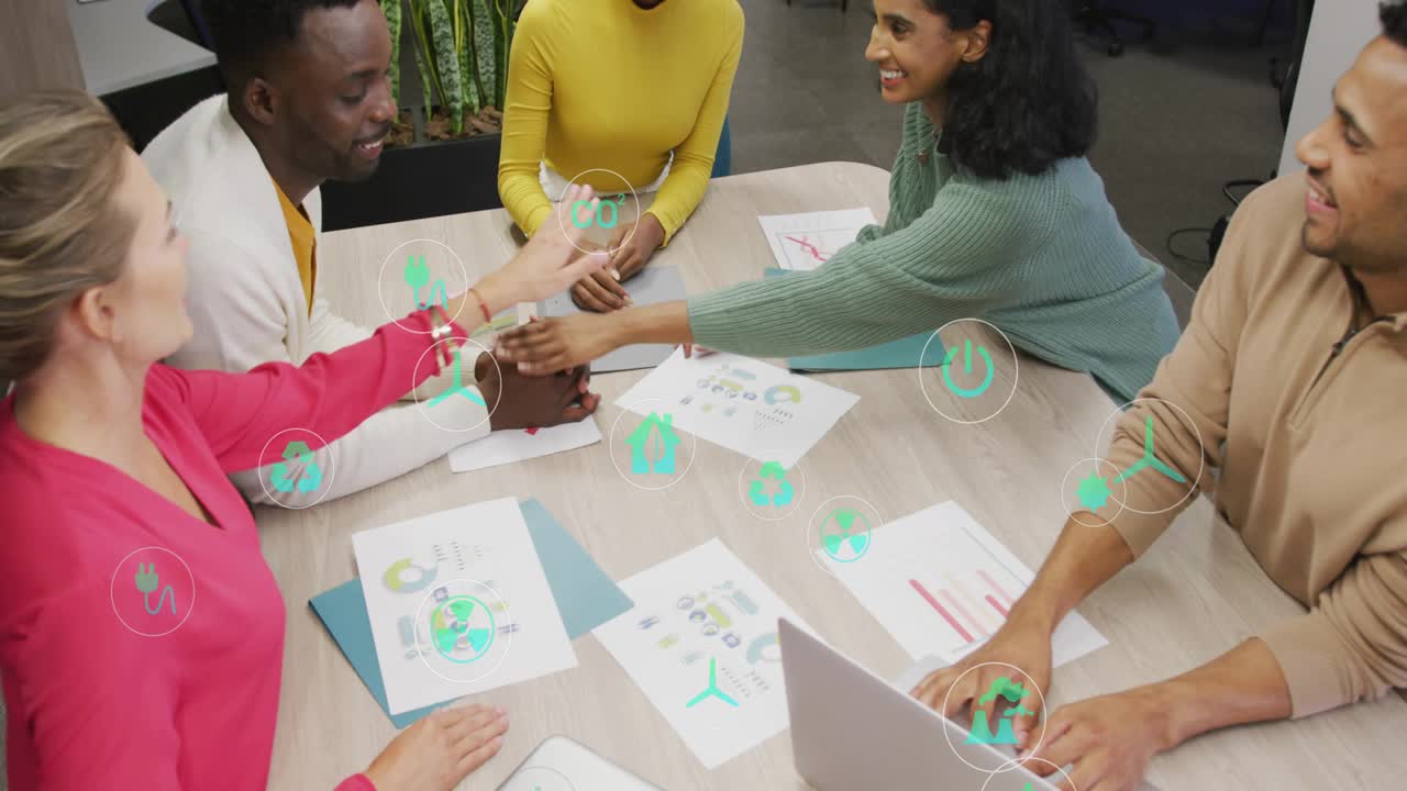Team typing on laptop passing charts aligning business stacking hands as green icons marking charts