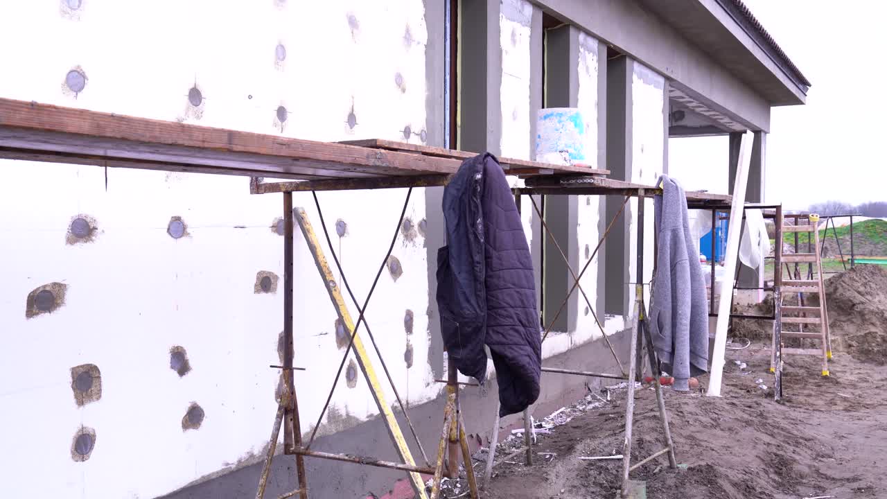 Scaffolding beside exterior insulation on house facade