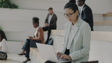 mujer de negocios trabajando en una computadora portátil en una oficina moderna