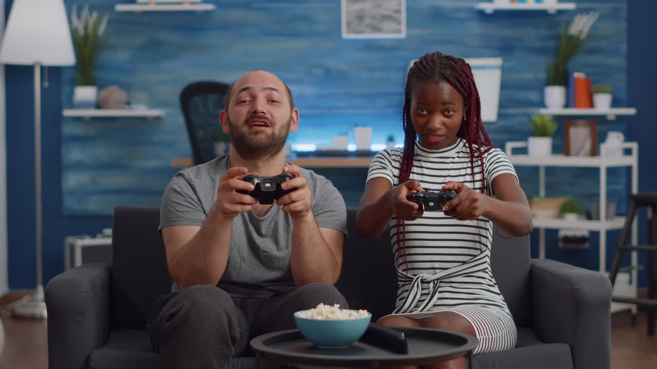 POV of interracial couple using controller for video game