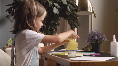 Blonde-Girl-Sitting-At-The-Desk-While-Working-With-Cardboard-2