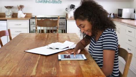 Teenage-Girl-With-Digital-Tablet-Revising-For-Exam-At-Home