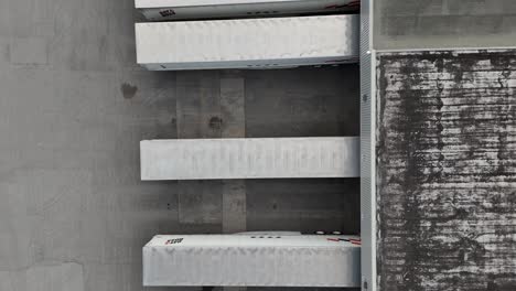 aerial drone view of trailers lined up at a distribution centre or warehouse, loading and unloading