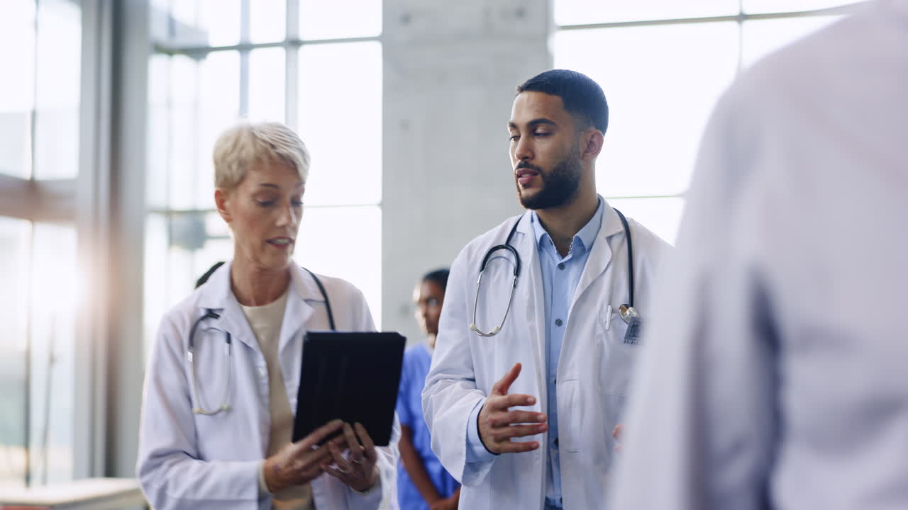 Tablet, teamwork or doctors walking in hospital
