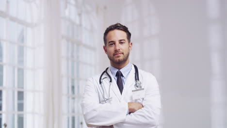 un joven médico de pie en un hospital
