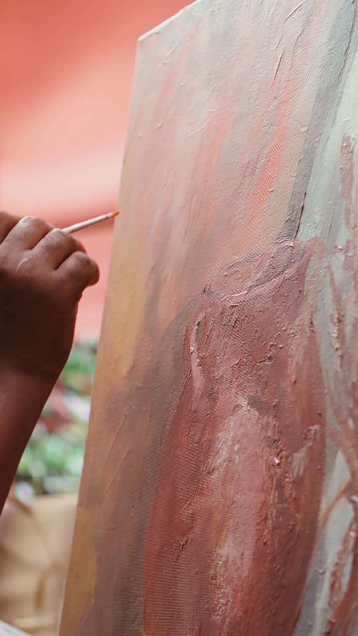 Close-up of Hand Painting on Canvas with Paintbrush