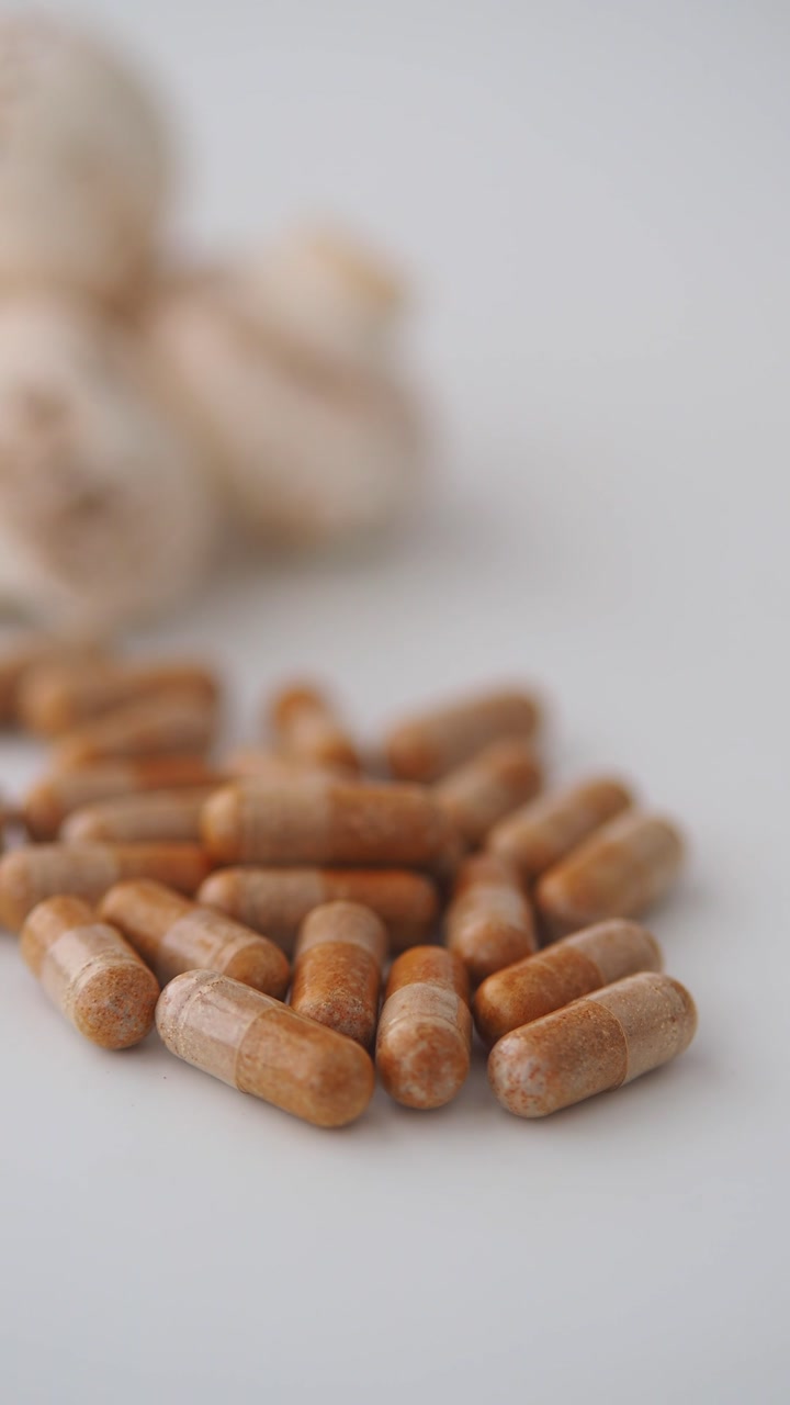 Pile of Brown Herbal Supplement Capsules on White Background
