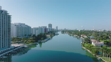Calm-water-surface-of-Indian-Creek-reflecting-trees-and-buildings-in-luxurious-residential-urban-borough.-Miami,-USA