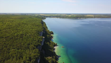 Aerial:-Rugged-rock-bluff-overlooks-clear,-cold-Lake-Huron-water