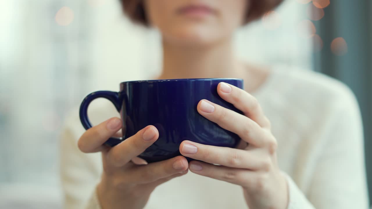 Una mujer bebiendo café.