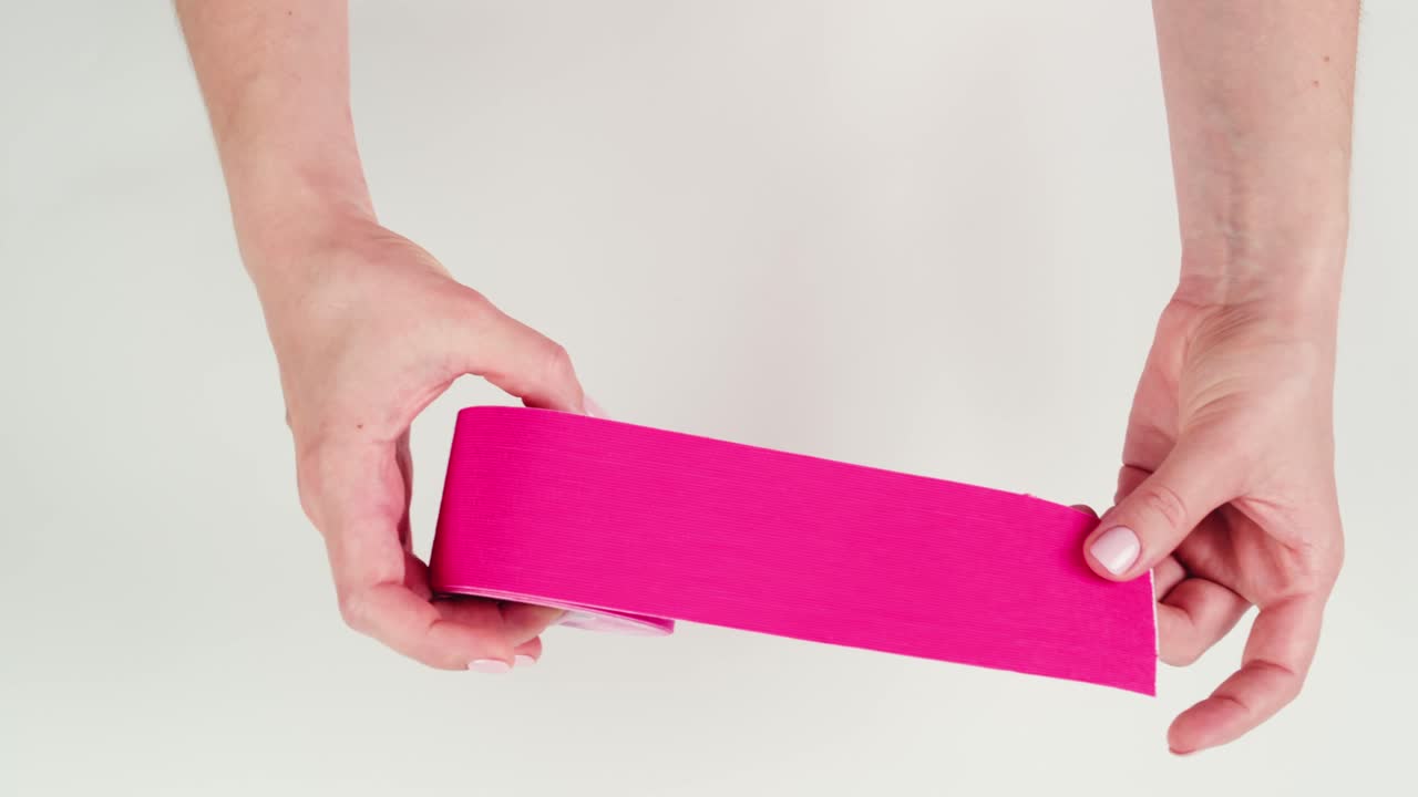 Kinesiology medical taping, doctor Physical therapist applying elastic surgical tape to patient body, treating injured knee young athlete.Post traumatic rehabilitation, sport physical therapy recovery