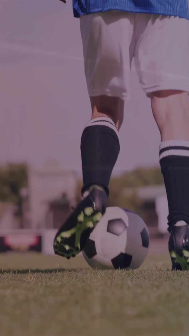 Video vertical: Jugadora de fútbol tocando el balón, regateando hacia la portería en césped con líneas métricas