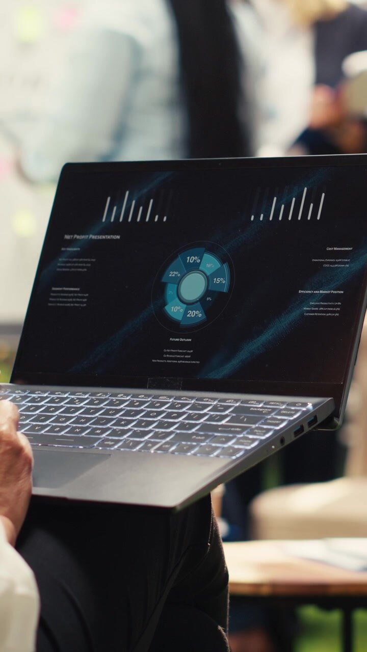 Vertical Video Businesswoman reviews laptop dashboard with charts during outdoor workshop