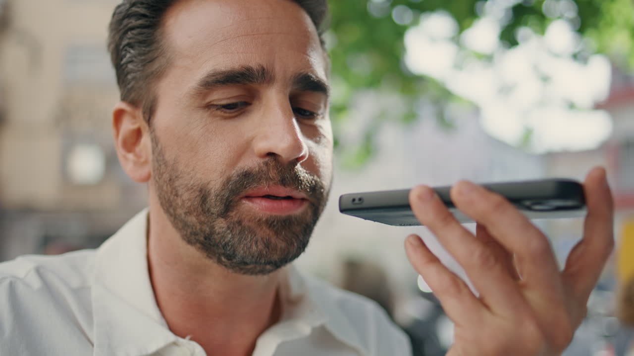 Successful executive sending audio use mobile phone greenery city cafe closeup