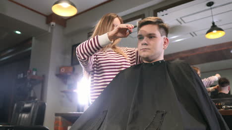 rear view of man client visiting haidresser and hairstylist in barber shop.