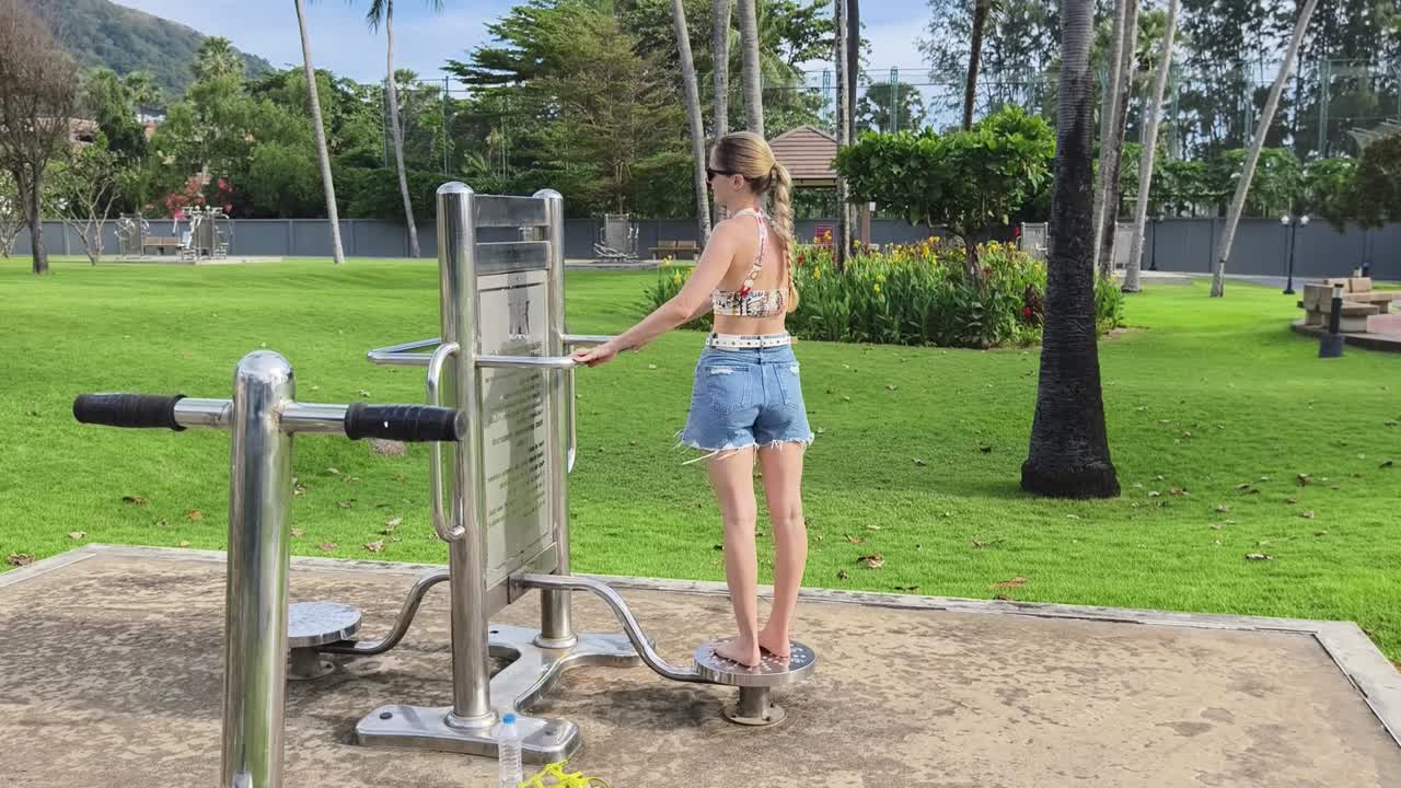 공원 에 있는 야외 체육관 에서 일 하는 여자