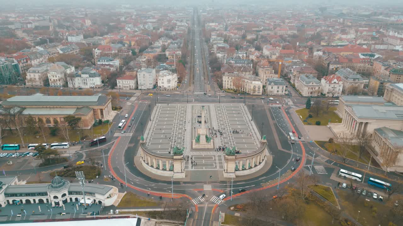 Bird's eye aerial footage of the Heroes Square in Budapest as traffic circulates around the iconic landmark where thousands gather everyday to honour legends