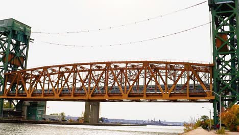 a lift bridge descends, with a canadian flag in the distance