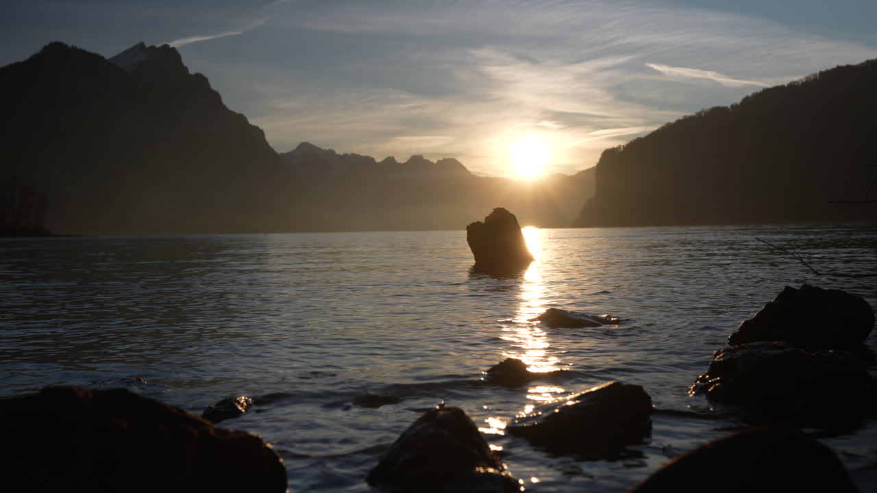 Sunset glow over Walensee lake with distant peaks and still water in Switzerland