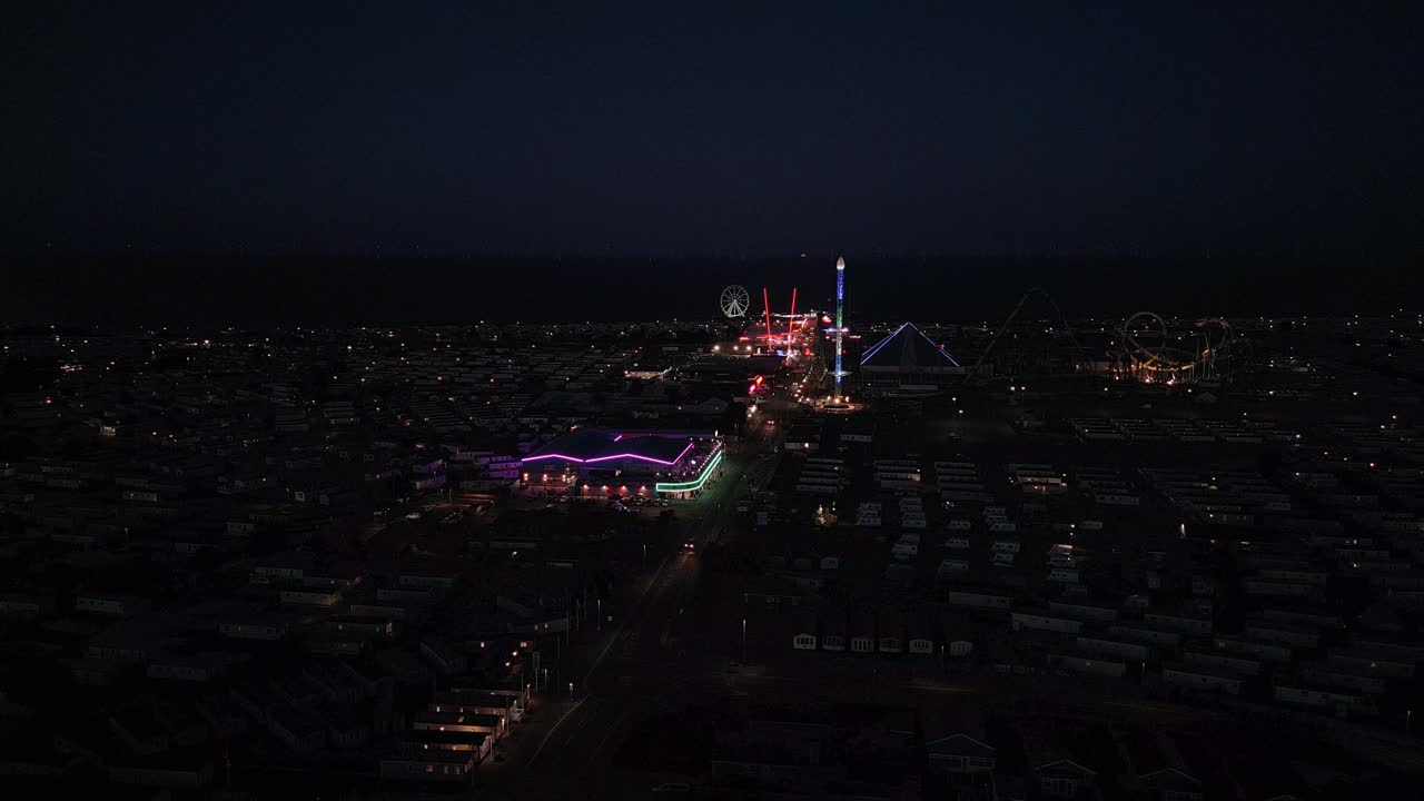 Dusk, aerial footage of a typical seaside amusement park. Fantasy Island amusement park at night in the seaside town of Ingoldmells near Skegness