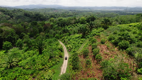 Vista-Aérea-Del-Coche-Cruzando-Lentamente-El-Bosque-Tropical-En-El-Camino-De-Polvo