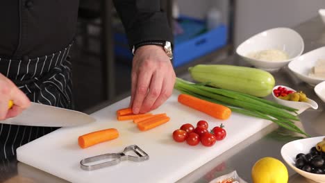 chef cortando zanahorias, tomates y otras verduras