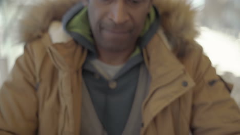 serious african american man using cell phone in cafe