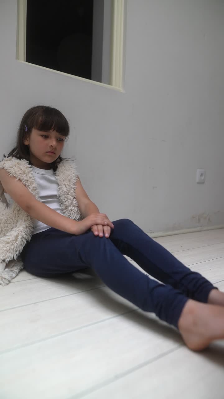 Una chica triste sentada en el suelo.