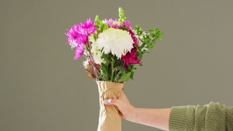 video de una mujer sosteniendo un ramo de flores con espacio de copia en un fondo gris