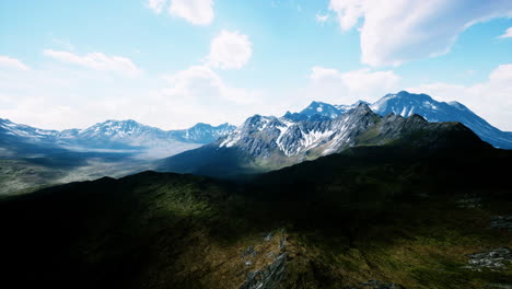 Aerial-Over-Valley-With-Snow-Capped-Mountains-In-Distance