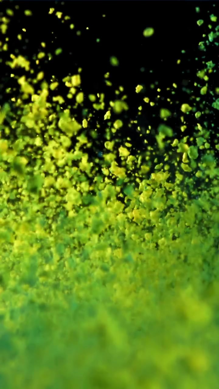 Particelle verdi e gialle vivaci che fluttuano su uno sfondo scuro