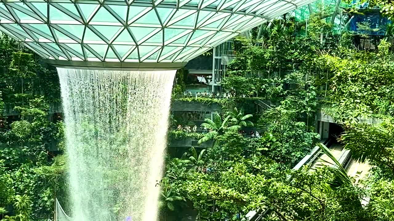 Singapore Jewel Indoor SloMo Waterfall Vortex at Changi Airport - whip pan left tree canopy to waterfall