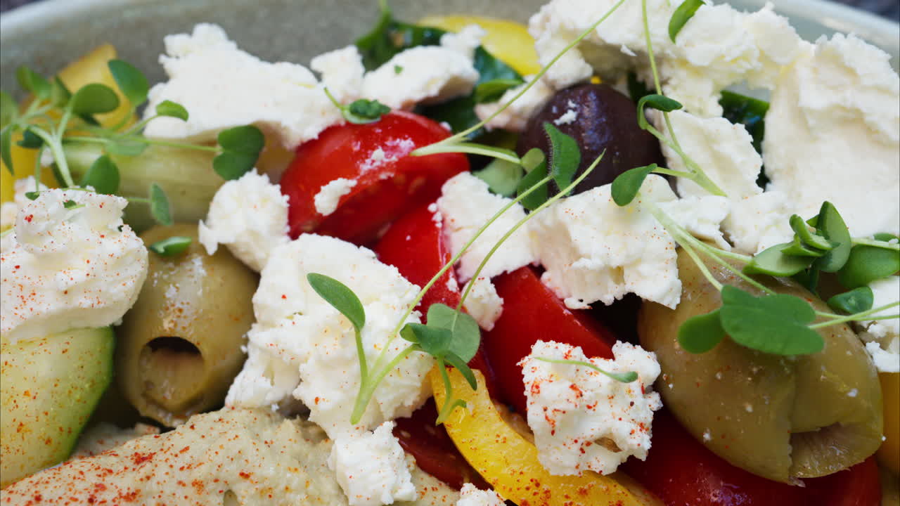 Close up of a greek salad with humus on a table at a terrace