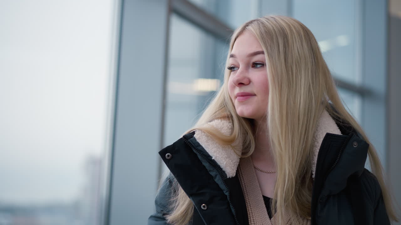 머리카락이 아지는 상적인 여성, 창문에서 볼 수 있는 반사, 깊은 생각, 흐릿한 도시 풍경 배경, 반사와 내성의 감각을 불러일으킨다.