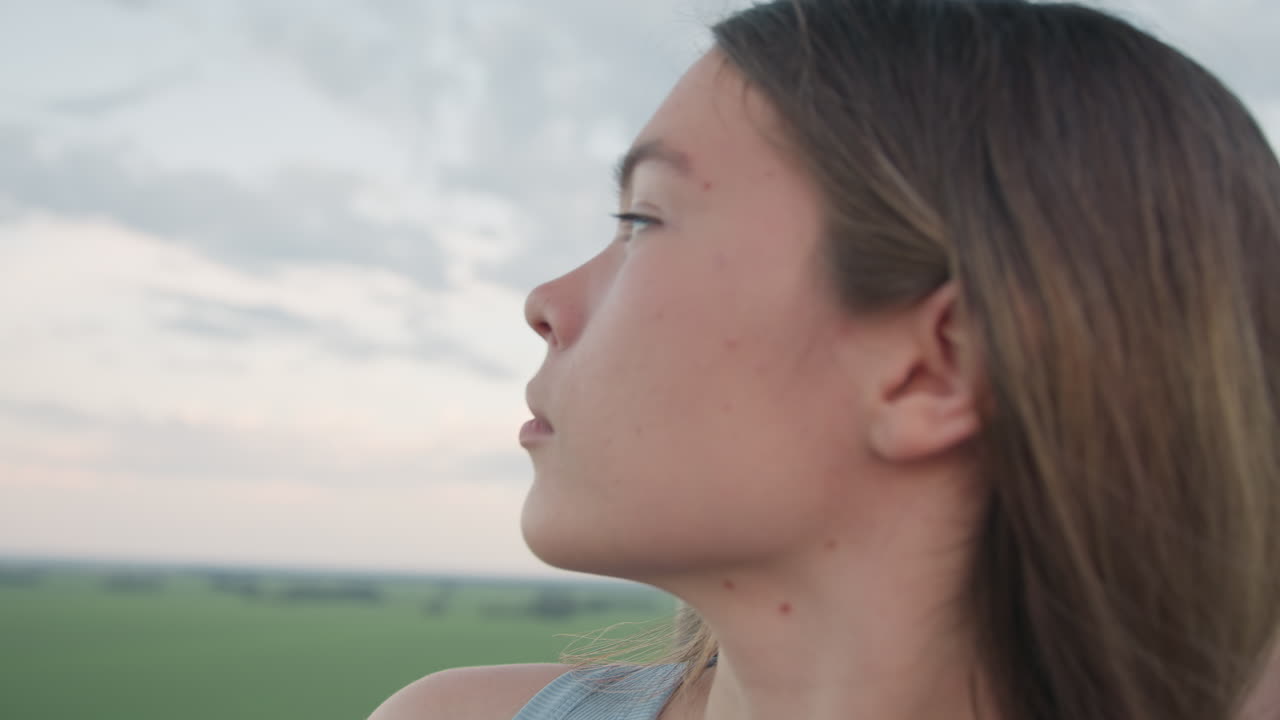 lady pointing panoramic countryside horizon to smiling boyfriend inside vibrant hot air balloon basket drifting above farmland with warm sunset light capturing romantic adventurous couple