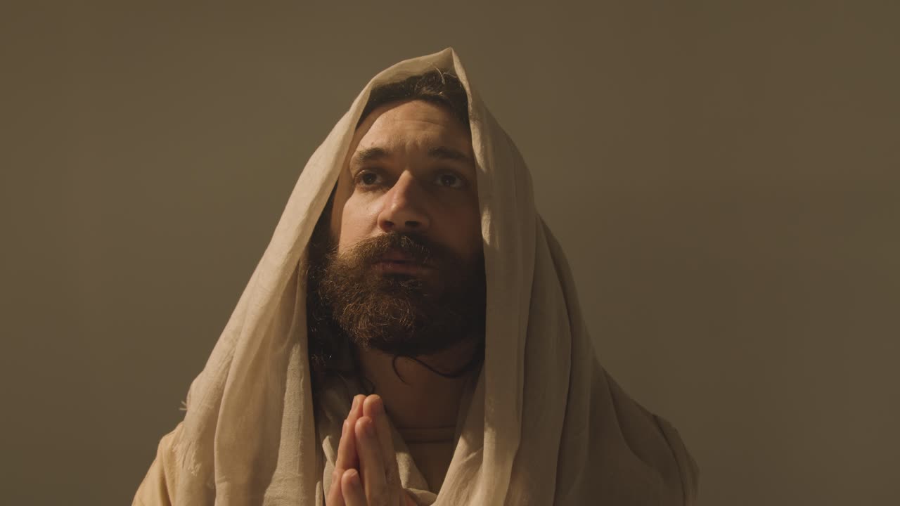 retrato de estudio de un hombre vestido con túnicas con cabello largo y barba que representa la figura de jesucristo orando 7