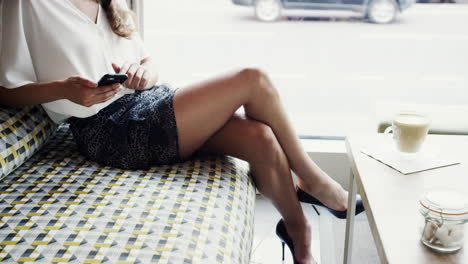 attractive business woman sexy legs using mobile smart phone cafe city commuters in background