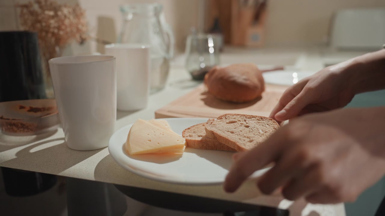 Bright kitchen island caucasian woman assembling quick brunch, music lover vibe with lively tempo, placing cheese on plate, bun on wooden board, mugs aligned, warm tones, modern utensils, tidy counter