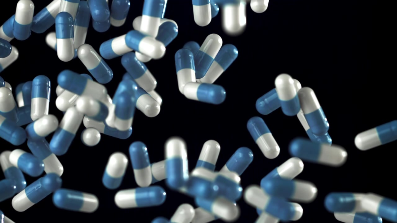 Capsule mediche blu e bianche che cadono al rallentatore