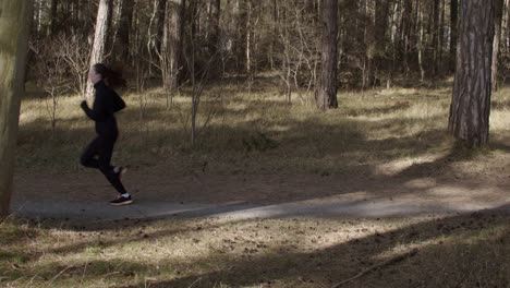 Woman-jogging-outdoor-in-forrest-on-a-sunny-warm-day