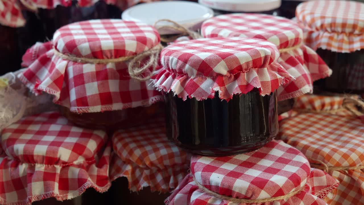 Closeup of jars of jam with red gingham fabric lids