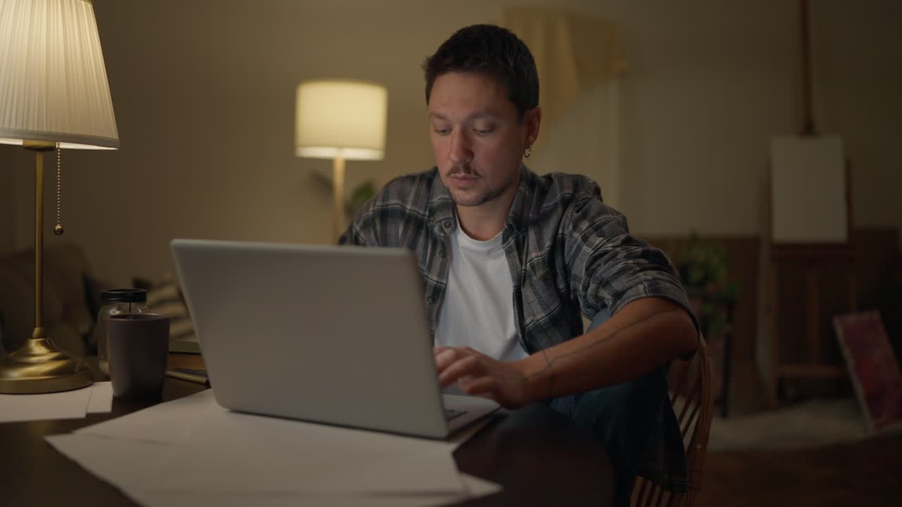 hombre trabajando en una computadora portátil por la noche