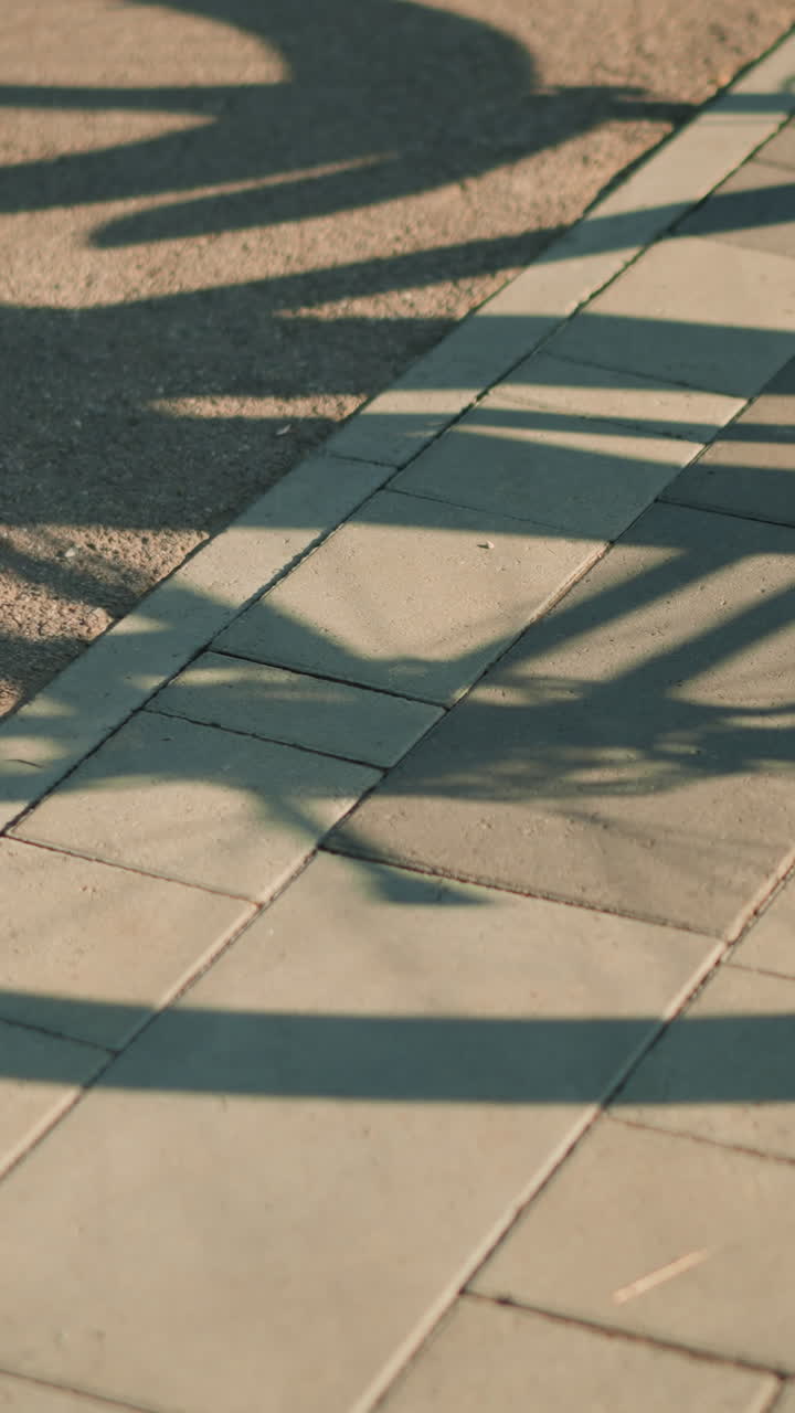 바닥 바닥에 던진 뒤집힌 자전거의 그림자, 눈에 보이는 뒷 타이어 회전, 따뜻한 빛에서 역동적인 실루 효과를 만니다.