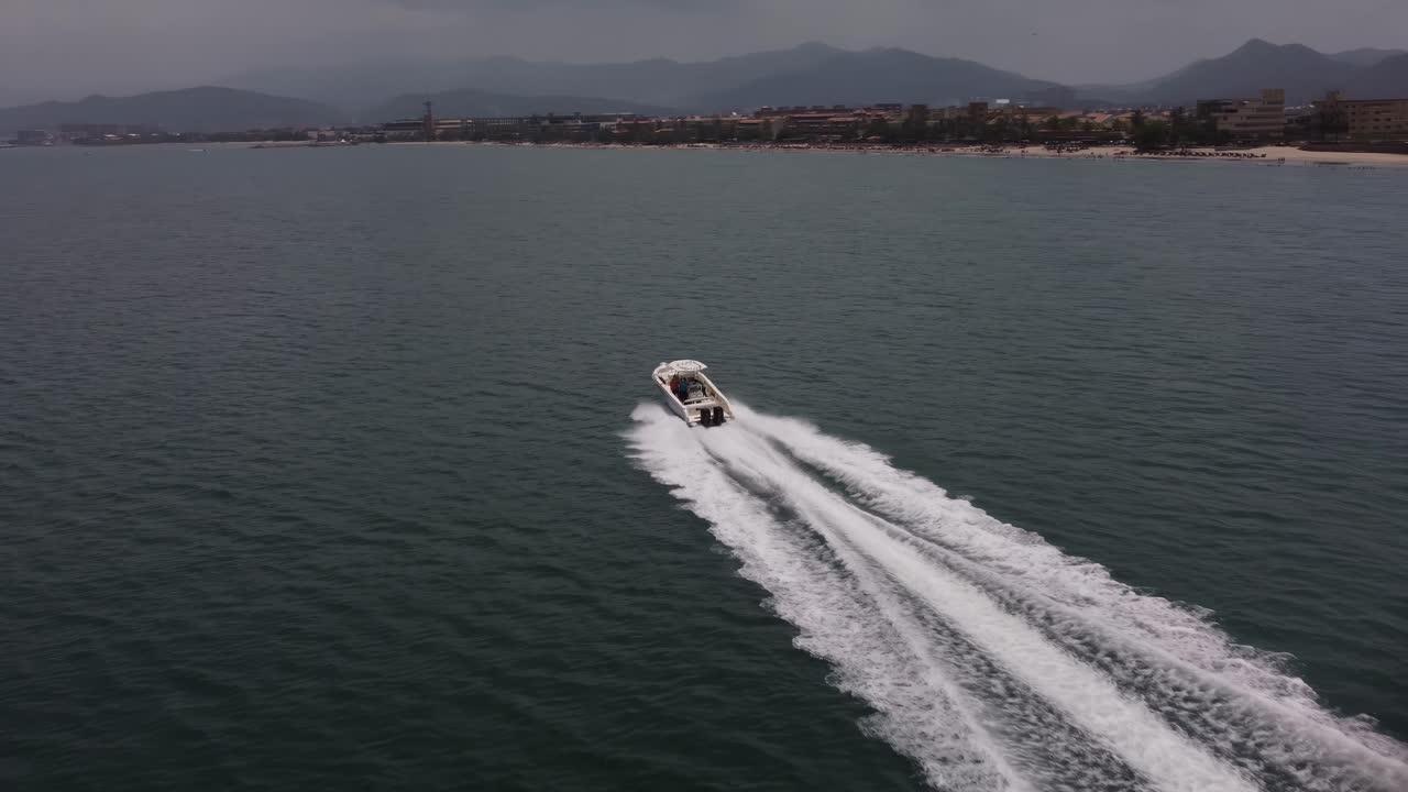 Una motoscafo che sfreccia sul mare con la città di Lechería sullo sfondo, situata in Venezuela.