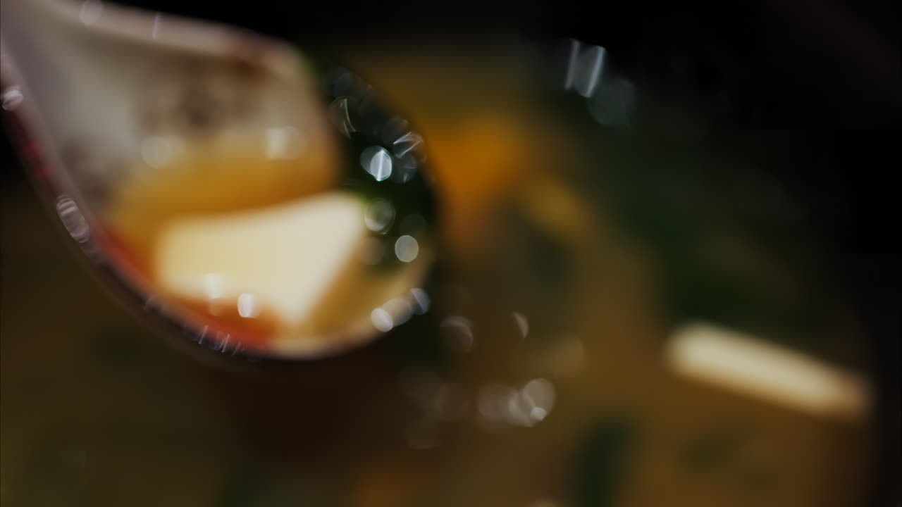 Close up of a woman mixing a miso soup at a restaurant
