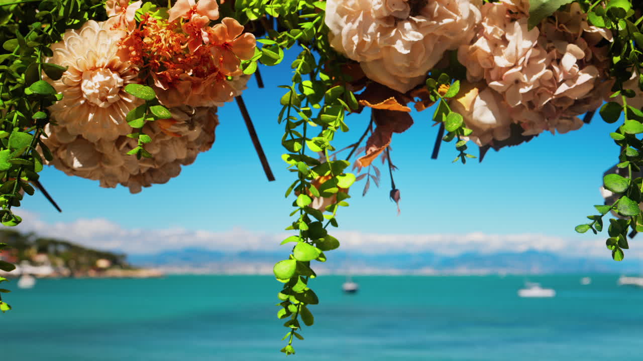 Close up of an orange flower arrangement with the blue sea on the background