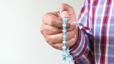 persona con cuentas de oración