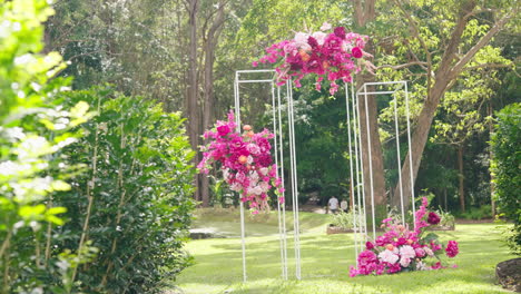 Zeitlupe-Zeigt-Den-Grünen-Busch-Bis-Zur-Farbenfrohen-Hochzeitslaube-Mit-Blumen-Im-Garten